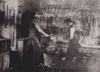 Kovač Janez Pokorn in vajenec Aleš Demšar v kovačnici ob Hudičevi brvi na Studencu, 1956 <em>Foto: Tone Mlakar, hrani Loški muzej Škofja Loka</em>