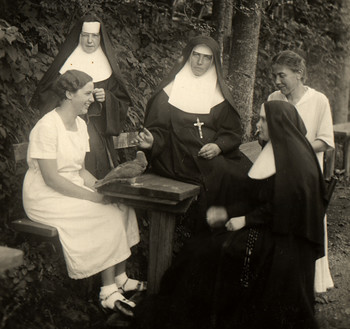 Papiga Oskar v družbi redovnic in gojenk učiteljišča na vrtu Loškega gradu. <em>Foto: Fototeka Loškega muzeja</em>