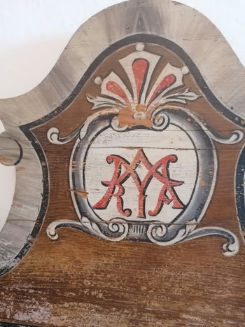 Na manjši ženski postelji je naslikan Marijin monogram.