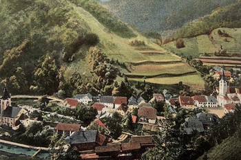 Železniki s cerkvijo sv. Antona Puščavnika (desno), razglednica, pred letom 1918, hrani Loški muzej Škofja Loka. 