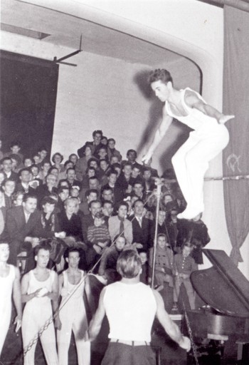 Telovadni nastop ob občinskem prazniku. Na drogu je Miloš Klemenčič, poleg pa stojijo Rudi Benedik, Janez Hude, Franc Pivk in Domine Bizjak, Telovadnica Partizan, 1957. <em>Foto: Fototeka Loškega muzeja</em>