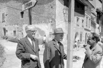 Dva izmed najstarejših slovenskih šoferjev: Janko N. Rogelj, 1. z leve (izseljenec iz ZDA), ki je prišel na tridnevni obisk k Tonetu Ješetu (v sredini), v Škofji Loki leta 1963. Oba sta se za šoferja izšolala še pred 1. svetovno vojno v Pardubicah na Češkem. <em>Foto: Edi Šelhaus, originalni negativ hrani Muzej novejše zgodovine Slovenije.</em>