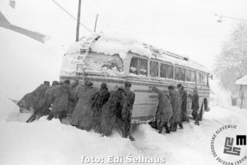 Ker ni šlo drugače, so potniki napeli vse sile, da so avtobus porinili iz zametov, Škofja Loka, 23. januar 1958. <em>Foto: Edi Šelhaus, originalni negativ hrani Muzej novejše zgodovine Slovenije.</em>